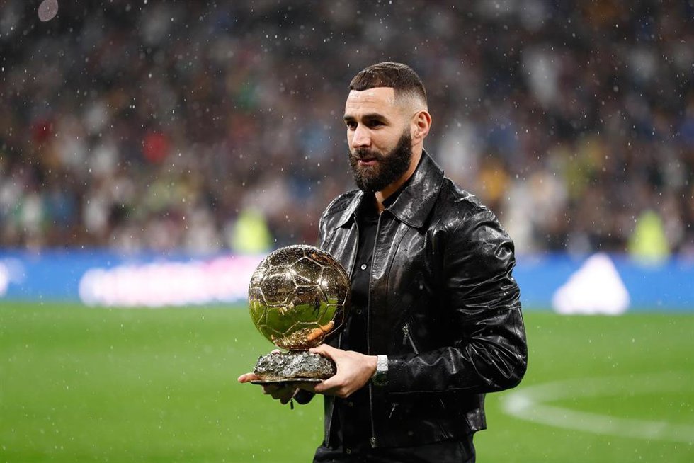 El jugador del Real Madrid Karim Benzema ofrece su Balón de Oro al Santiago Bernabéu.