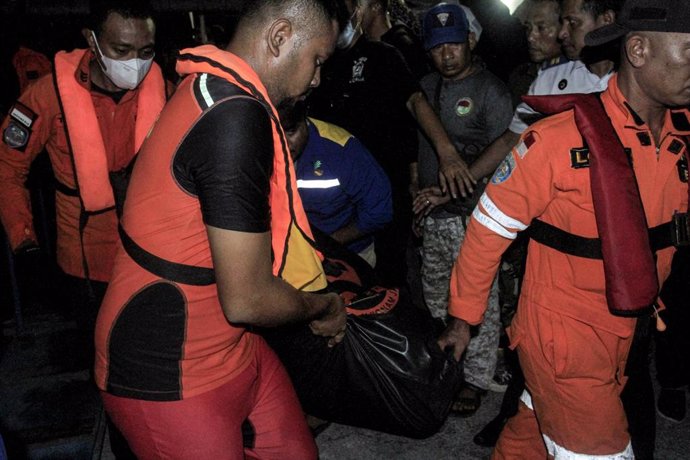 Miembros de los equipos de búsqueda y rescate llevan el cuerpo de una víctima del incendio de un barco en la provincia de Nusa Tenggara Oriental, Indonesia.