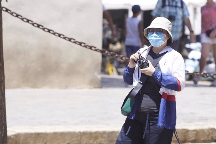 Archivo - Una turista asiática se protege del sol con una prenda de manga larga para evitar quemaduras en el primer día de la segunda ola de calor, a 7 de julio de 2022 en Sevilla (Andalucía, España)