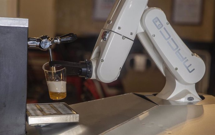 Archivo - Un brazo robótico instalado en un bar de la cadena La Gitana Loca sirviendo una cerveza.