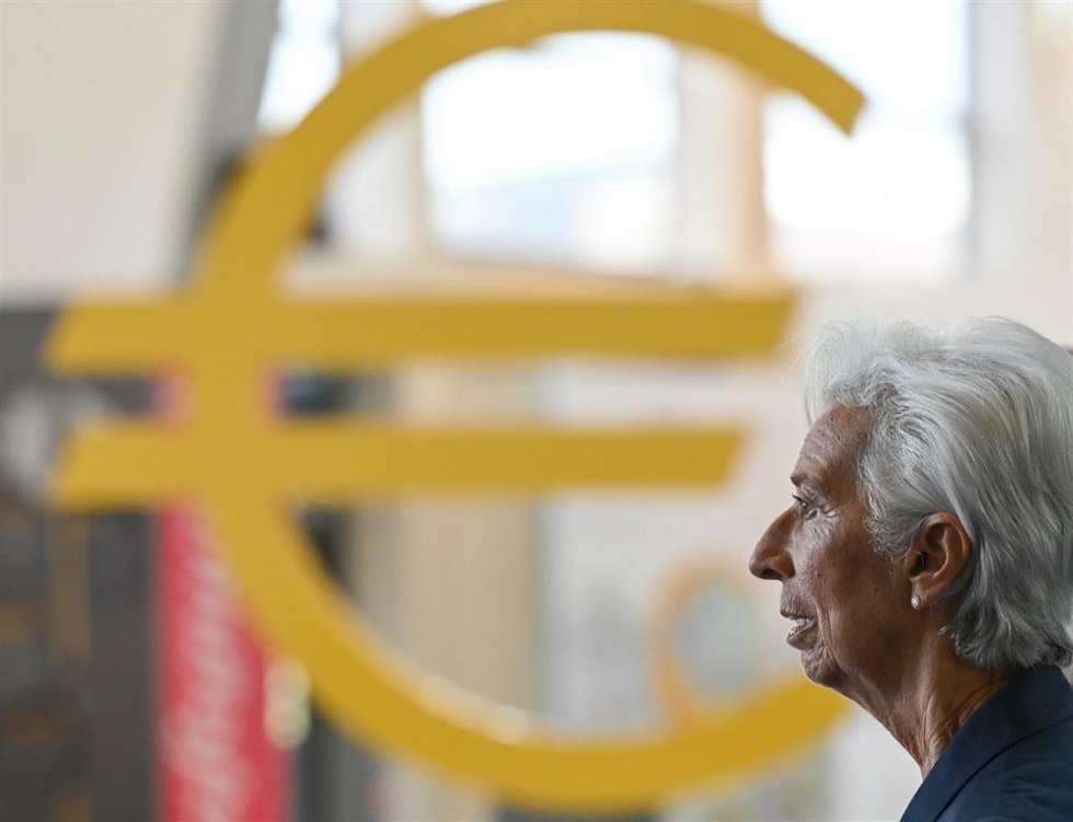 19 October 2022, Hesse, Frankfurt_Main: Christine Lagarde, President of the European Central Bank (ECB), passes a euro sign as she walks through the ECB's entrance hall. Photo: Arne Dedert/dpa