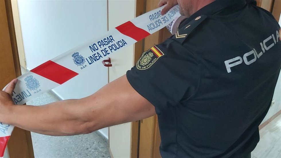 Archivo - Un agente de la Policía Nacional con una cinta de 'No Pasar ', en una imagen de archivo