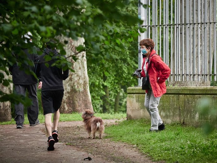 Archivo - Una mujer paseando a su perro.