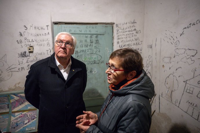 25 October 2022, Ukraine, Yahidne: German President Frank-Walter Steinmeier speaks with eyewitnesses who were held hostage in the basement of a school near the village of Yahidne, while the days of hostage-taking and the dates of those who died can be s