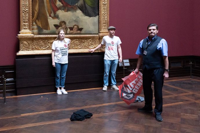 Archivo - 23 August 2022, Saxony, Dresden: Two environmental activists of the group "Last Generation" stand by the painting "Sistine Madonna" by Raphael at the Old Masters Picture Gallery. Photo: Sebastian Kahnert/dpa