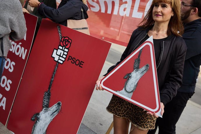 Una mujer sostiene una pancarta en una concentración por la defensa de los derechos de los animales frente al Congreso de los Diputados, a 25 de octubre de 2022, en Madrid (España).