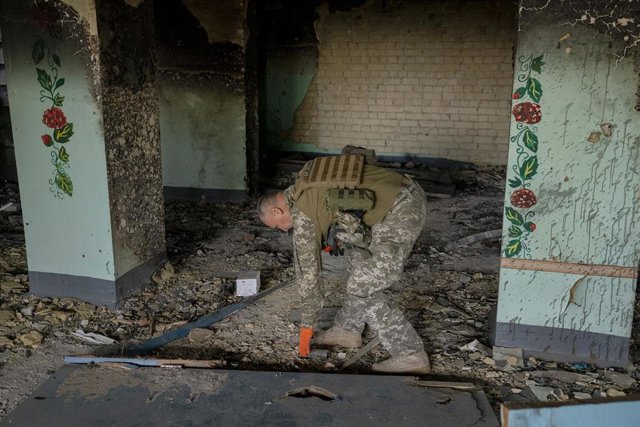 Archivo - Un militar ucraniano supervisa los destrozos en un edificio de Járkov