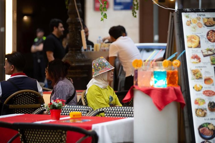Archivo - Una persona sentada en una mesa de un bar