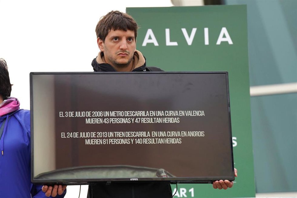 Un familiar de una víctima en el accidente de Alvia sujeta una pantalla de televisión con una imagen del exdirector de Seguridad en la circulación de Adif, Andrés Cortabitarte, mientras declara en el juicio por el accidente del Alvia, en la Cidade de la