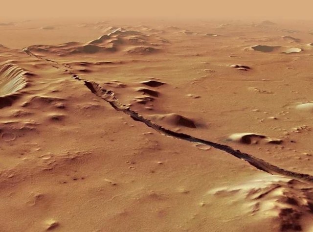 Una de las fracturas del sistema de la Fosa Cerbero que corta a través de colinas y cráteres, indicando su relativa juventud