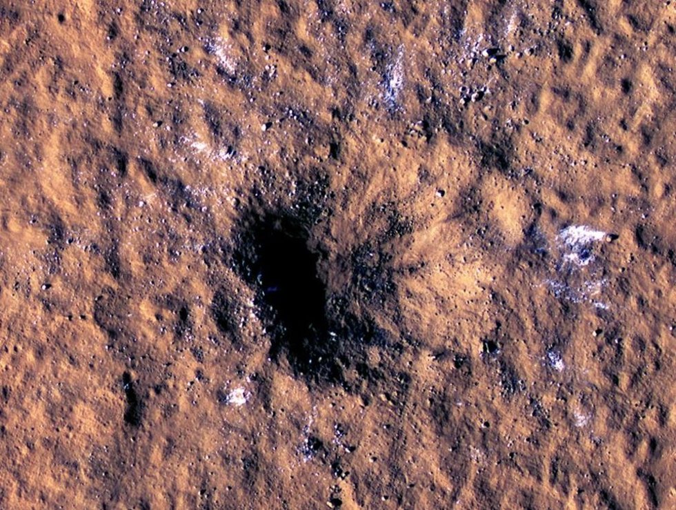 Se pueden ver bloques de hielo de agua del tamaño de una roca alrededor del borde de un cráter de impacto en Marte, vistos por el Experimento científico de imágenes de alta resolución (cámara HiRISE) a bordo del Mars Reconnaissance Orbiter de la NASA.