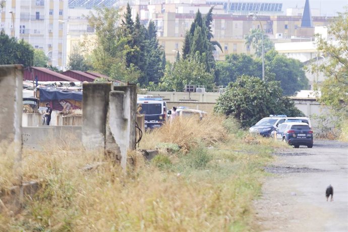Detalle de varios coches de la Policía Nacional tras el tiroteo en el asentamiento chabolista del Vacie.