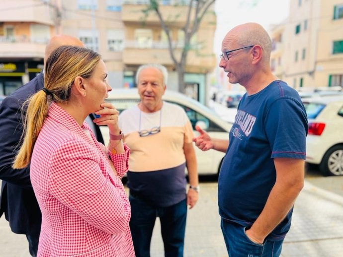 La presidenta del PP, Margalida Prohens, conversa con vecinos ante la sucursal okupada de la avenida San Fernando.