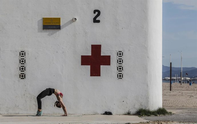 Archivo - Una mujer hace deporte en la playa de la Malvarrosa
