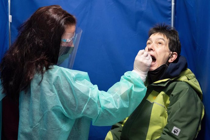 21 October 2022, Saxony, Dresden: Sandra Nessmann (L) takes a swab from Ilona Seitel for a Coronavirus quick test in a Corona test centre. Photo: Sebastian Kahnert/dpa
