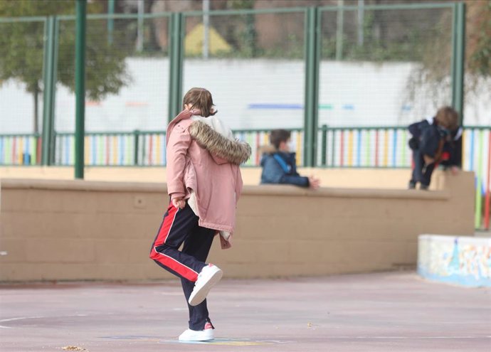 Archivo - Una niña juega en el recreo en un colegio