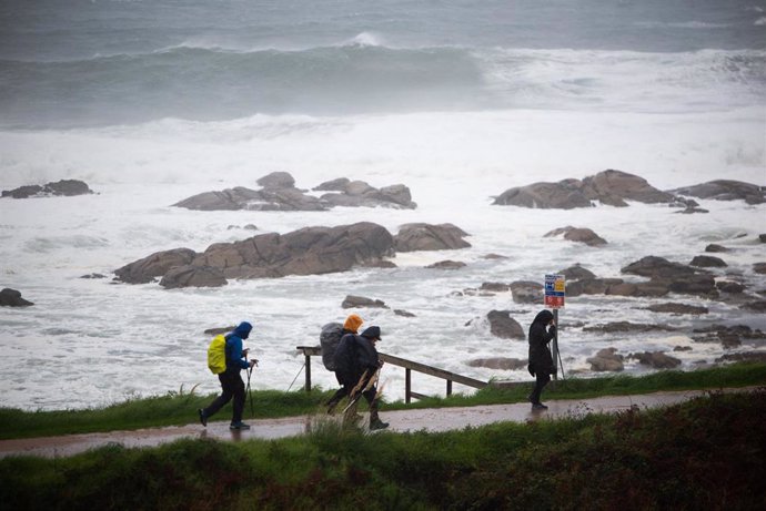 Varios peregrinos realizan el Camino de Santiago, a pesar del temporal, en la zona de Santa Maria de Oia hasta Cabo Silleiro, a 20 de octubre de 2022, en Pontevedra, Galicia, (España). 