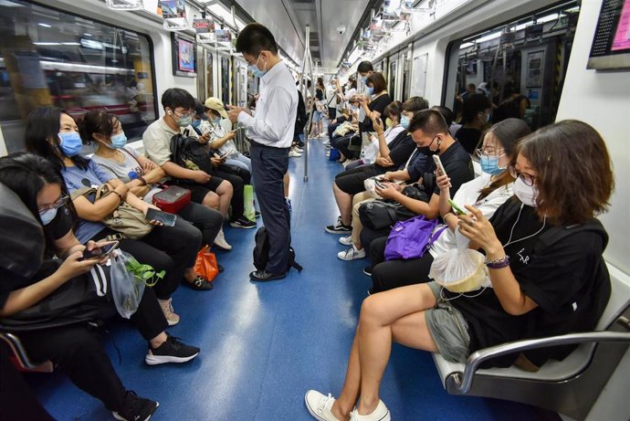 Archivo - 29 July 2022, China, Beijing: People check their phones on the Beijing subway. Photo: Sheldon Cooper/SOPA Images via ZUMA Press Wire/dpa