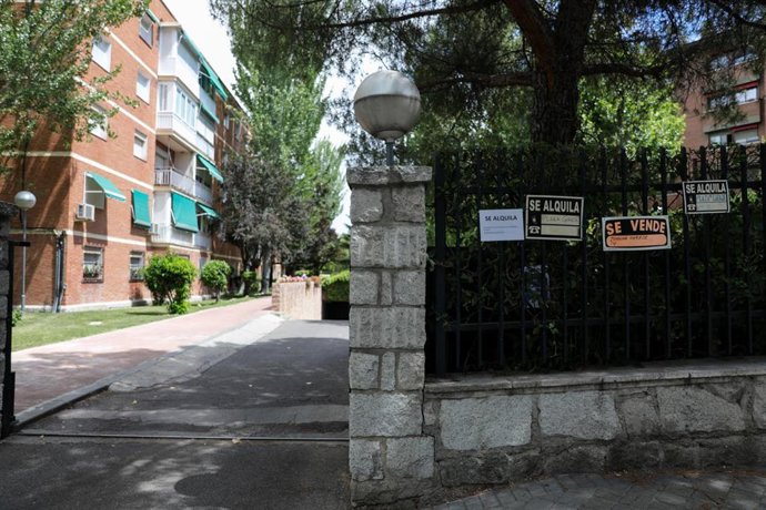 Archivo - En la valla de la puerta de una urbanización se ven colgados tres carteles de 'Se alquila plaza de Garaje' y uno de 'Se vende plaza de garaje'.