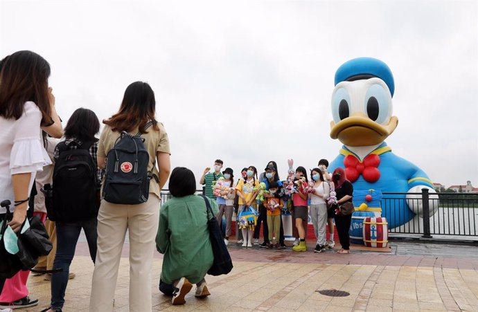 Archivo - Turistas posan para una foto en el Disney Resort de Shanghái