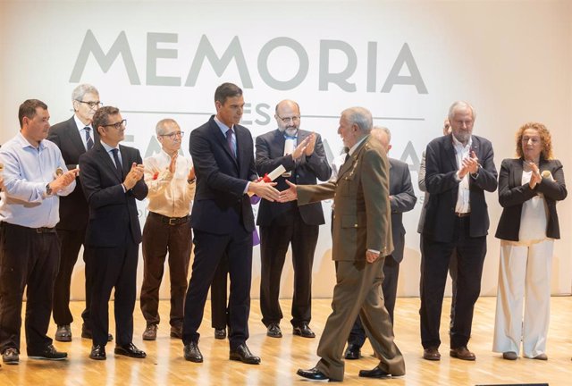 El presidente del Gobierno, Pedro Sánchez (5i), entrega un diploma al teniente coronel Fernando Reinlein (4d) en el acto conmemorativo con motivo del Día de Recuerdo y Homenaje a todas las víctimas del golpe militar, la guerra y la dictadura en la Sala de