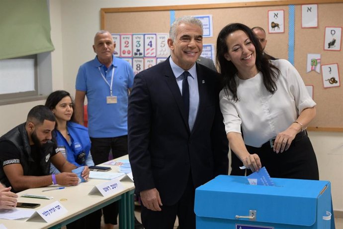 HANDOUT - 01 November 2022, Israel, Tel Aviv: Israeli Prime Minister Yair Lapid (L) and his wife Lihi cast their ballot at a polling station in the Ramat Aviv Gimel school during the 2022 Israeli general election. Photo: Amos Ben Gershom/GPO/dpa - ATTEN