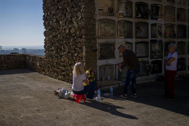 Un hombre limpia un nicho en el cementerio de Montjuïc con motivo del Día de Todos los Santos , a 1 de noviembre de 2022, en Barcelona
