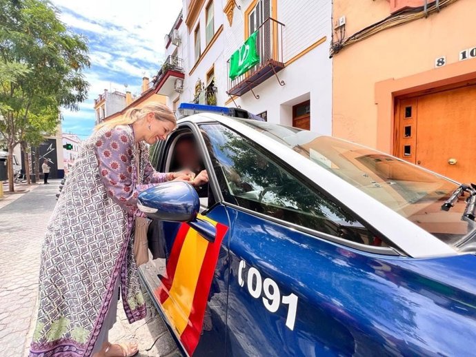 Cristina Peláez junto a un patrullero de la Policía Nacional.