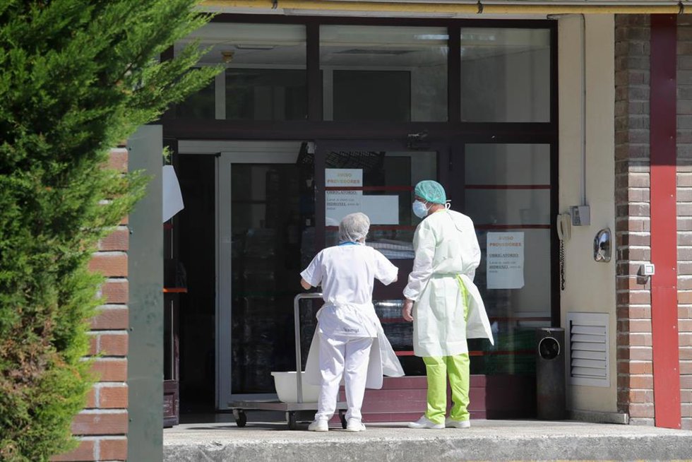 Archivo - Dos trabajadores conversan en la puerta de la residencia de Las Gándaras 