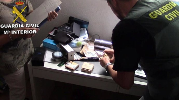 Un agente de la Guardia Civil con materiales incautados a la banda de estafadores.