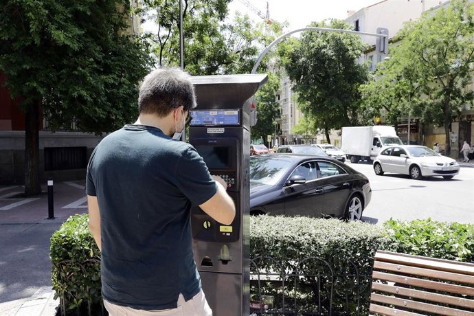 Archivo - Un hombre utiliza el parquímetro del Servicio de Estacionamiento Regulado (SER) de Madrid.