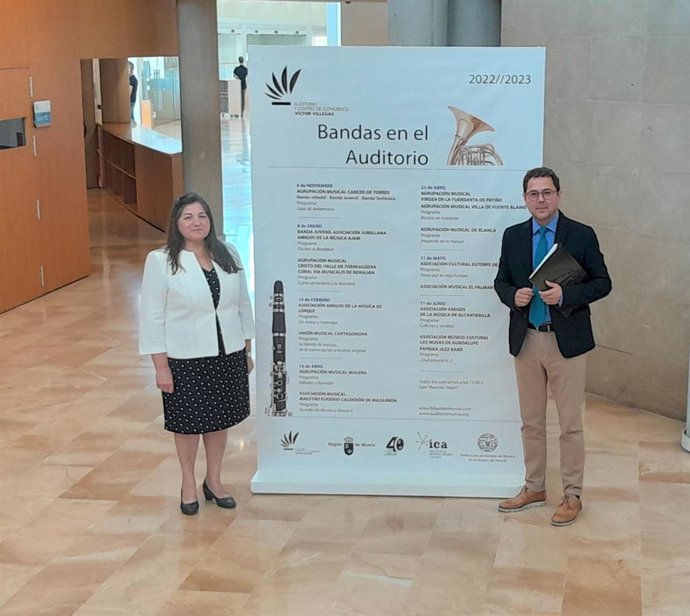 El director general del Instituto de las Industrias Culturales y las Artes, Manuel Cebrián, junto a la presidenta de la Federación de Bandas de Música de la Región de Murcia, Ginesa Zamora, posan ante el cartel anunciador del ciclo 'Bandas en el Auditor