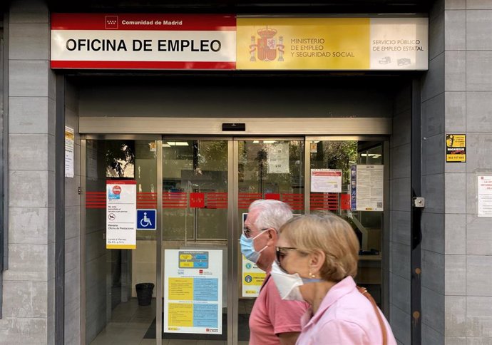 Dos personas pasan por una oficina de empleo de Madrid.