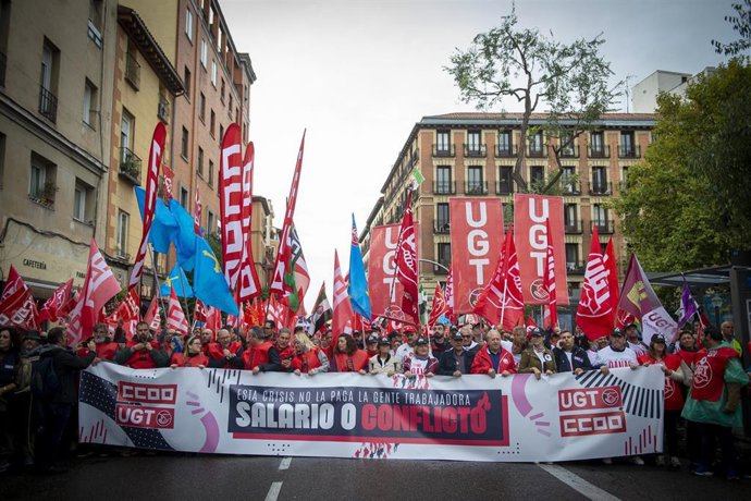 Centenares de personas sostienen banderas durante la movilización convocada por CCOO y UGT este jueves en Madrid.