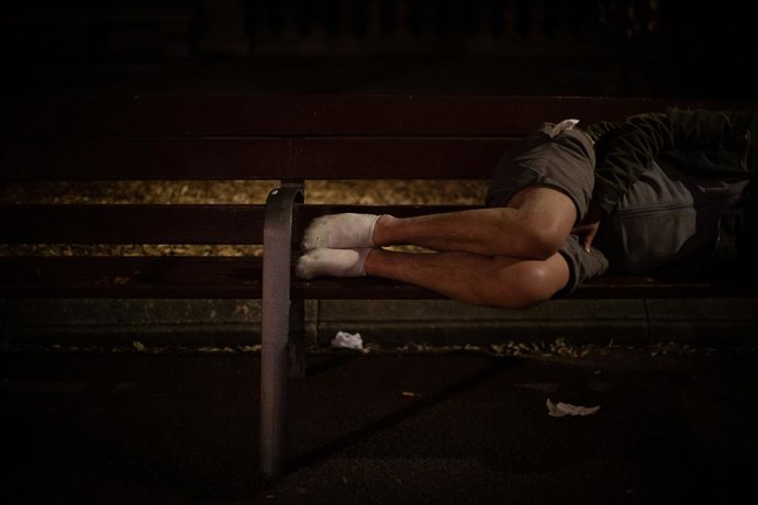 Archivo - Imatge d'arxiu d'un home que dorm sobre un banc a Barcelona