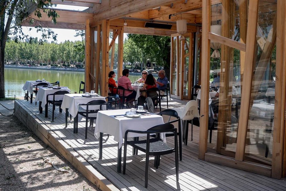 Archivo - Varias personas disfrutan de la hostelería en las terrazas de las inmediaciones del lago de la Casa de Camp, en Madrid (España). 