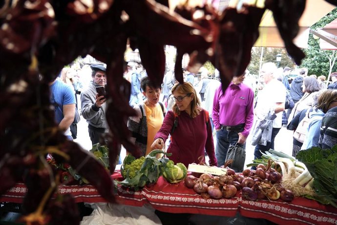 Varias personas en un puesto de verduras y hortalizas en feria del agro