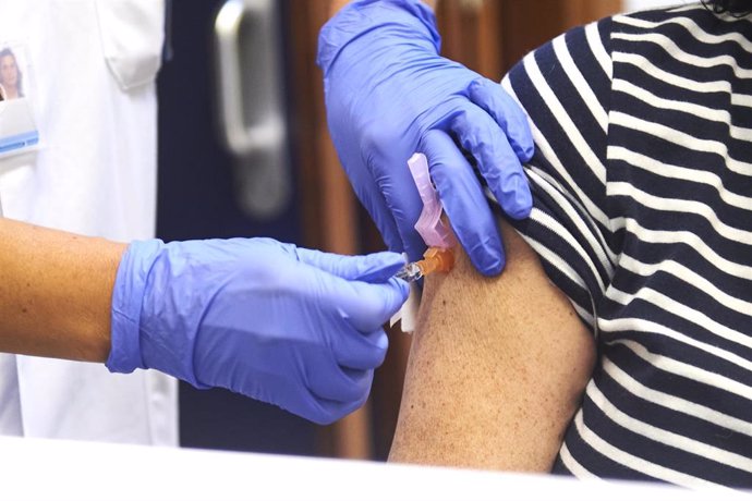 Un enfermero vacuna de la gripe a una mujer durante el inicio de la campaña de vacunación contra la gripe en Cantabria, en el centro de salud de Puertochico, a 10 de octubre de 2022, en Santander, Cantabria (España).  