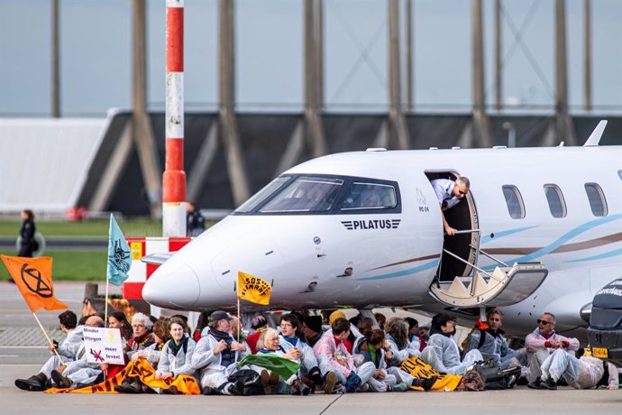 Activistas climáticos bajo un avión privado en el Aeropuerto de Ámsterdam-Schiphol