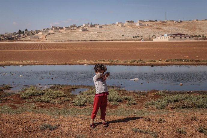 Archivo - 28 September 2022, Syria, Idlib: A Syrian child stands in front of a pond of contaminated water at a camp for internally displaced people near the Syrian-Turkish borders. According to Early Warning, Alert and Response Network (EWARN), a total 