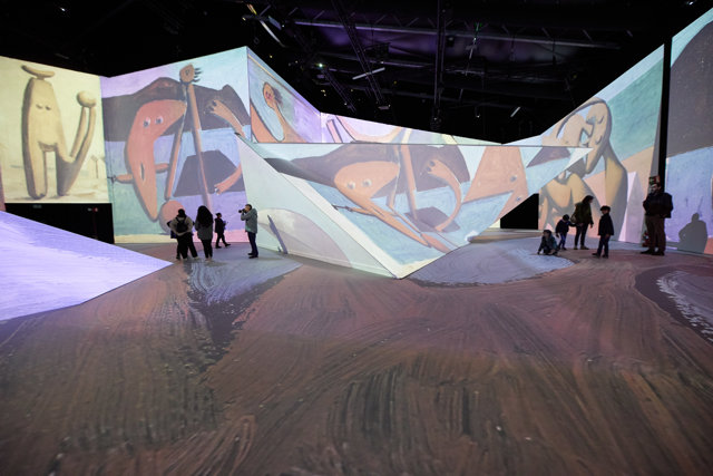 Varias personas pasean por una sala en la que se proyectan obras de Picasso en la exposición ‘Imagine Picasso’ en Ifema Madrid, a 5 de noviembre de 2022