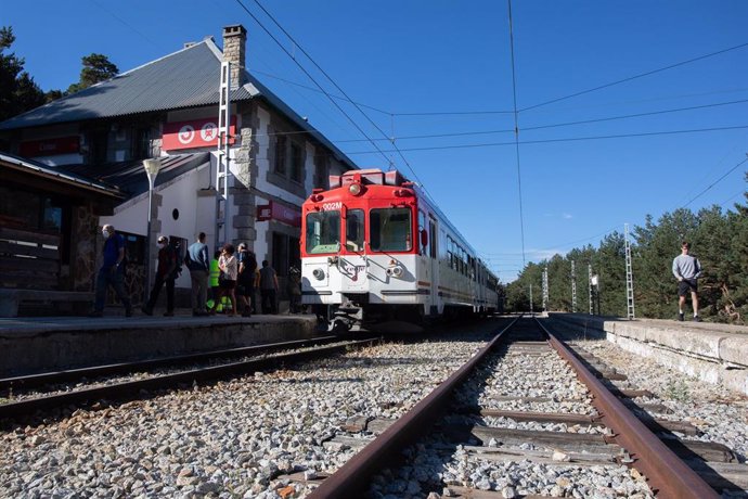 Archivo - Viajeros junto al tren en el andén de la estación de Cotos, a 3 de septiembre de 2022