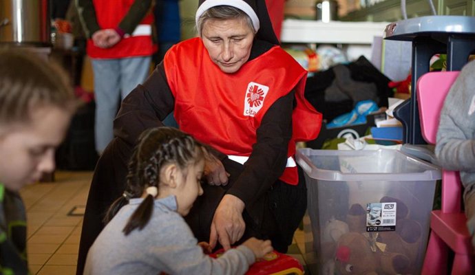 Una religiosa de Cáritas con un grupo de niños.