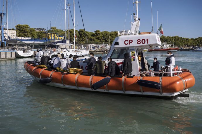 30 October 2022, Italy, Roccella Jonica: Migrants sit on board a patrol boat, as 55 migrants, mainly from Iran and Afghanistan and arriving from Turkey, had been rescued by the Italian Coast Guard and the Finance Police and taken to Porto Delle Grazie -