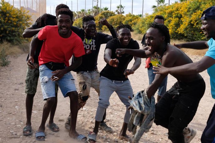 Archivo - Varios migrantes se dirigen al Centro Temporal de Inmigrantes (CETI), mientras celebran el salto de la valla de Melilla, en una imagen de 24 de junio de 2022.