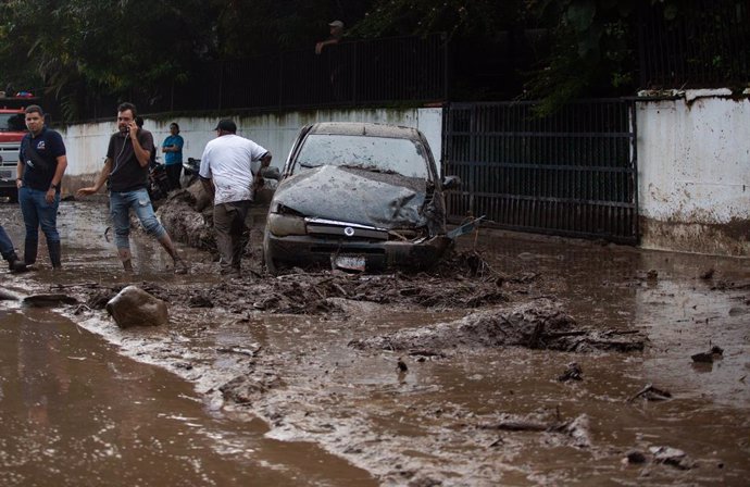 17 October 2022, Venezuela, Maracay: People and vehicles get stuck in the mud that came onto the roads due to flooding and landslides after heavy rains. Photo: Juan Carlos Hernandez/ZUMA Press Wire/dpa
