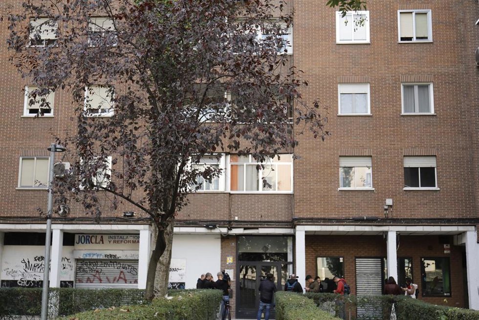 Varias personas frente al portal de la vivienda donde un hombre ha matado a su pareja y a su hija en común, a 7 de noviembre de 2022, en Móstoles (Madrid).