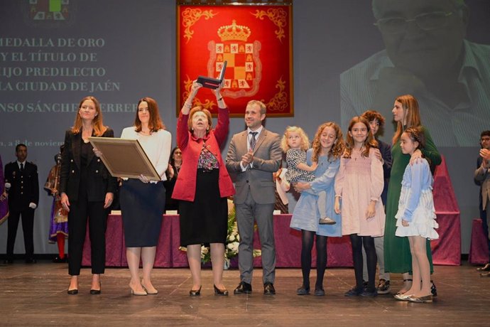 Momento en el que la esposa de Alfonso Sánchez eleva la Medalla de Oro entregada por el alcalde