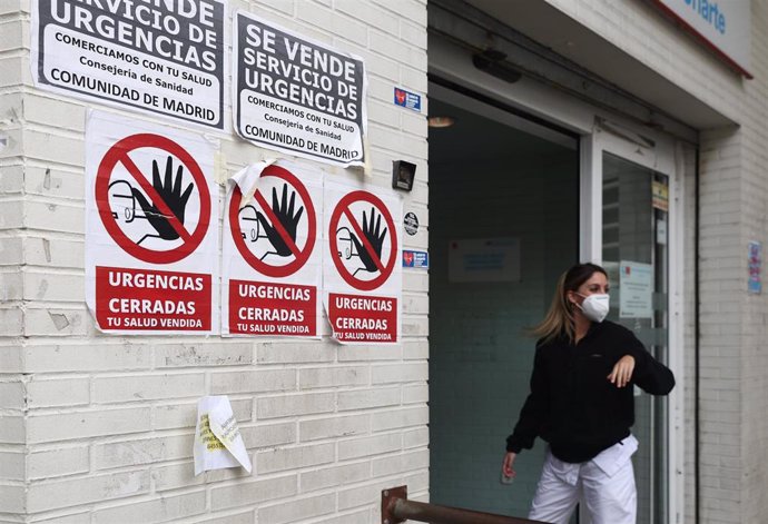 Una sanitaria con mascarilla en la puerta del Centro de Salud Ángela Uriarte, donde hay carteles de protesta que rezan 'Urgencias Cerradas, tu salud vendida', a 21 de octubre de 2022, en Madrid (España). La Comunidad de Madrid abrirá el próximo jueves 2