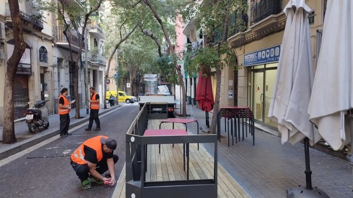 Operarios instalan una plataforma para consolidar una terraza en el barrio de Poblesec de Barcelona.